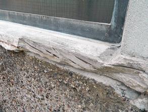 Heavily damaged concrete window sill