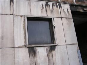 Spalled and chipped concrete panels of an office building